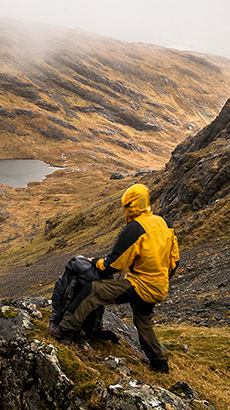 Man with yellow jacket in the mountains - sustainability